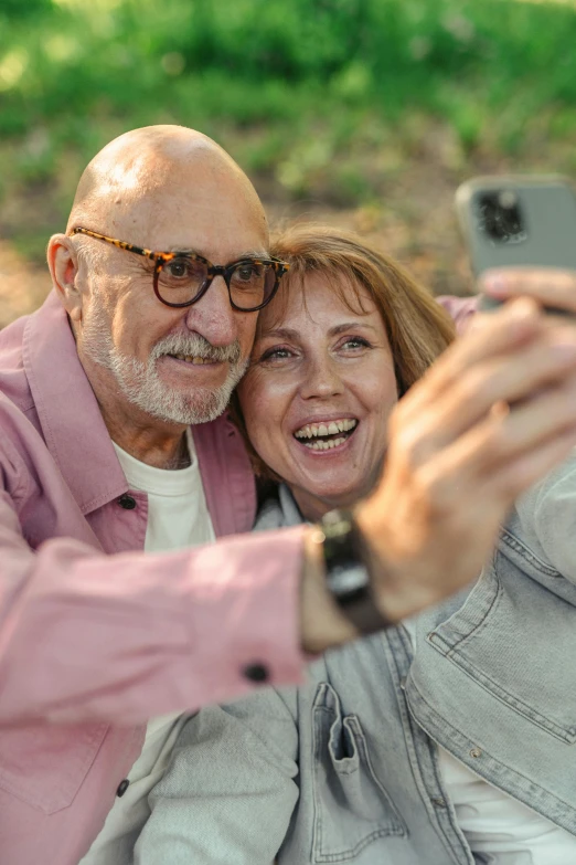 a man and woman taking a selfie in the park, trending on pexels, renaissance, an oldman, wearing small round glasses, bald, brown