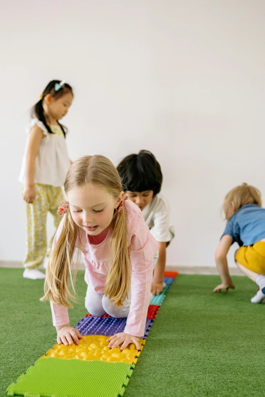 a group of children playing with toys in a room, bent over posture, school curriculum expert, young girls, lachlan bailey