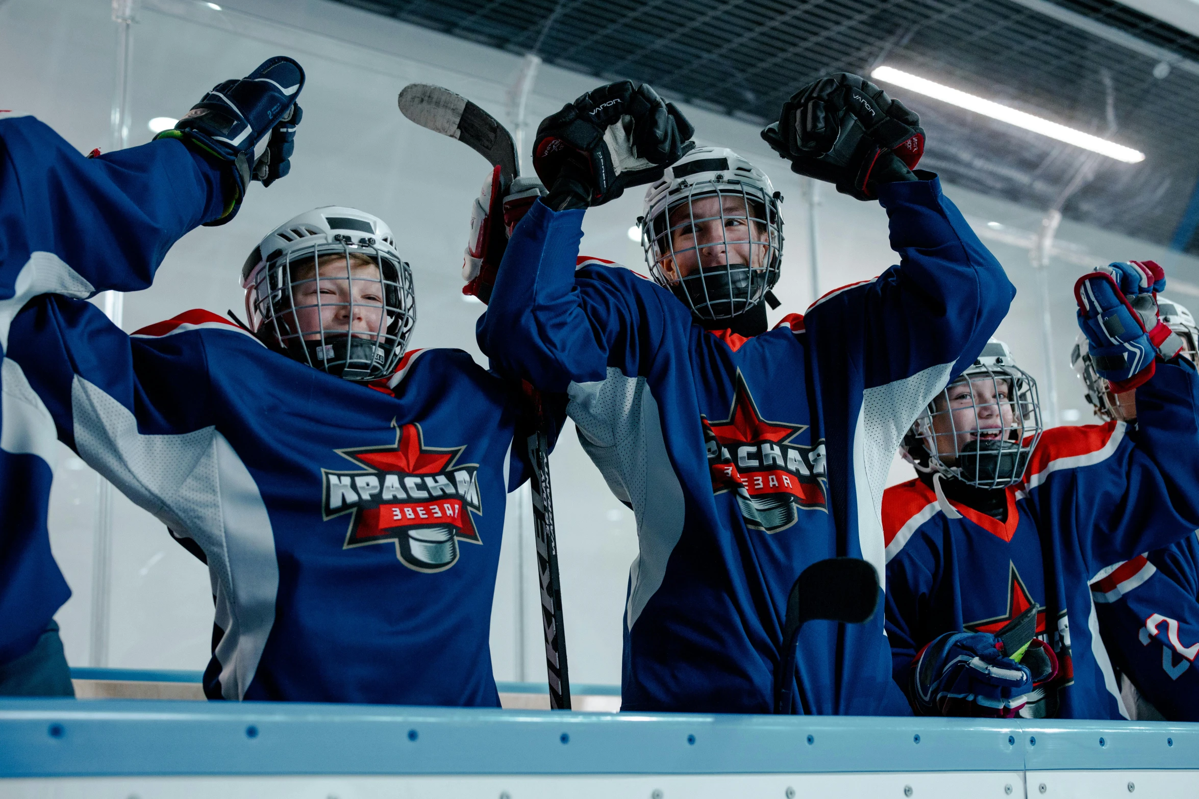 a group of young men standing on top of a hockey rink, shutterstock, official screenshot, lachlan bailey, cheering, abram games