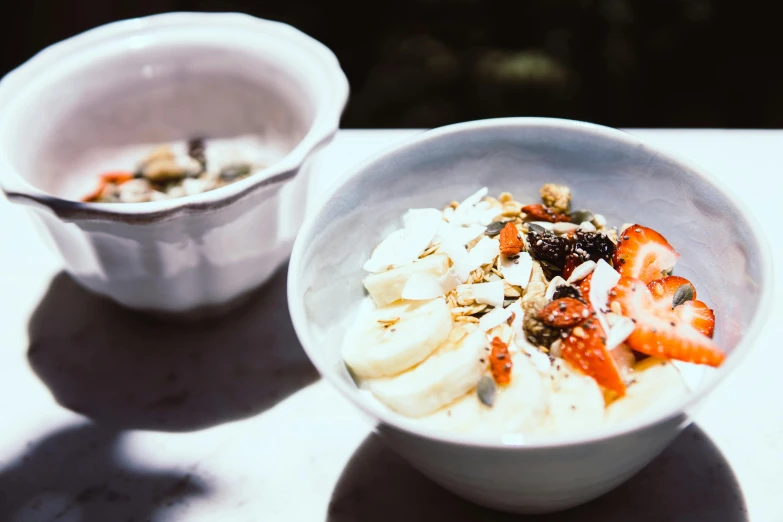 a couple of bowls of food sitting on top of a table, unsplash, 🎀 🗡 🍓 🧚, natural light outside, background image, thumbnail