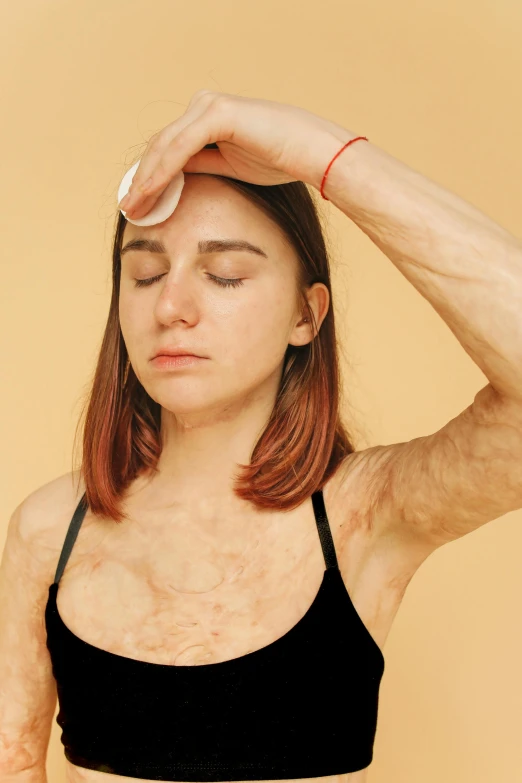 a woman in a black bra top with her hands on her head, an album cover, by Ellen Gallagher, trending on pexels, burn scar left cheek, human-skin pelt, clothes made out of veins, h3h3