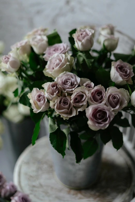 a close up of a vase of flowers on a table, featured on pinterest, romanticism, grey and silver, lilac, roses, various sizes