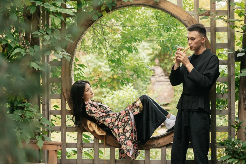 a man standing next to a woman in a garden, by Julia Pishtar, pexels contest winner, intricate hakama, relaxing, casual black clothing, ukrainian