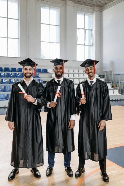 a group of three men standing next to each other, shutterstock, academic art, graduation photo, sports photo, black, indoor picture