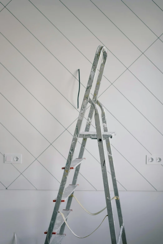 a ladder that is leaning against a wall, by Carey Morris, trending on pexels, with matte white angled ceiling, bright thin wires, tools, panel