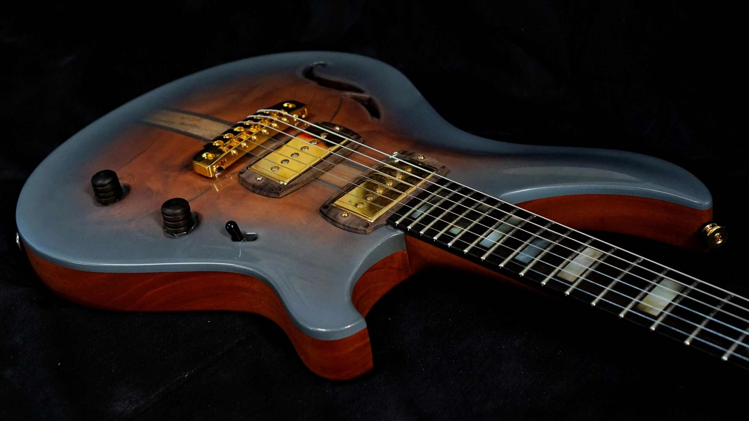 a close up of a guitar on a black background, an airbrush painting, by Arnie Swekel, pexels contest winner, gradient brown to silver, steel gray body, ground level shot, restored colors