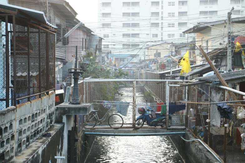 a river running through a city next to tall buildings, inspired by Steve McCurry, unsplash, houses on stilts, back alley, thai architecture, 2022 photograph