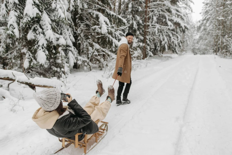 a man riding a sled down a snow covered road, pexels contest winner, visual art, people on a picnic, brown, white, swedish