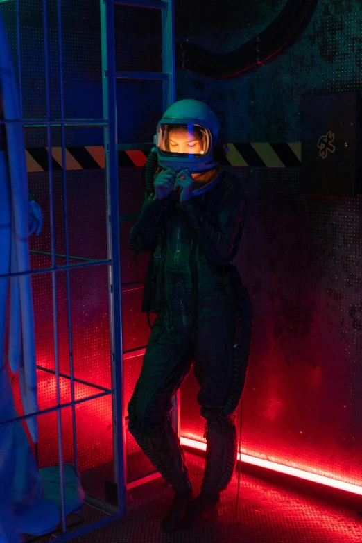 a man in a space suit standing in a cage, pexels contest winner, holography, photograph of a techwear woman, wax figure, dark visor covering face, spaceship hallway