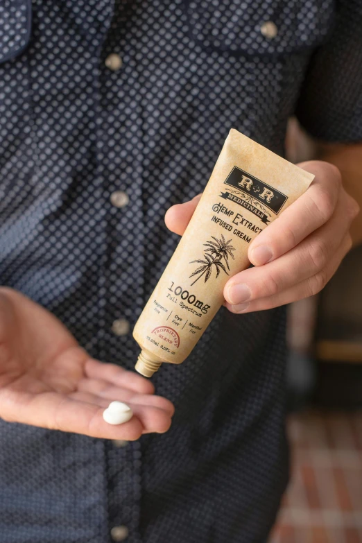 a man holding a tube of sunscreen cream, unsplash, photorealism, hemp, on wood, ultra - detailed and intricate, palms