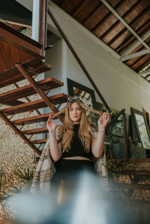 a woman sitting on the ground with her hands in the air, a portrait, pexels contest winner, light and space, bali, in a cabin, channeling third eye energy, britt marling style