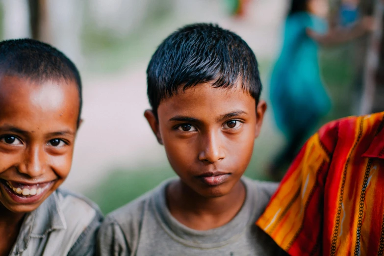 a couple of young boys standing next to each other, trending on unsplash, hurufiyya, bangladesh, close - up of the faces, educational, anthropology photo”