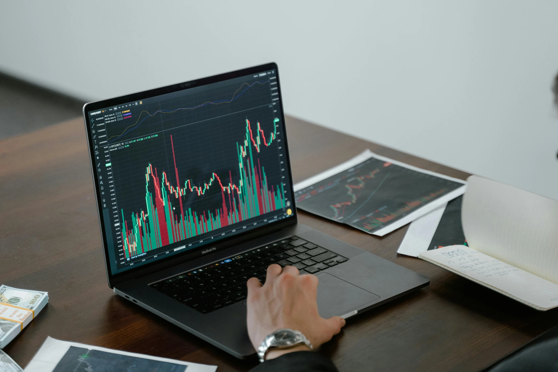 a man sitting at a desk using a laptop computer, trending on pexels, analytical art, displaying stock charts, qirex, giving a speech, a man wearing a black jacket