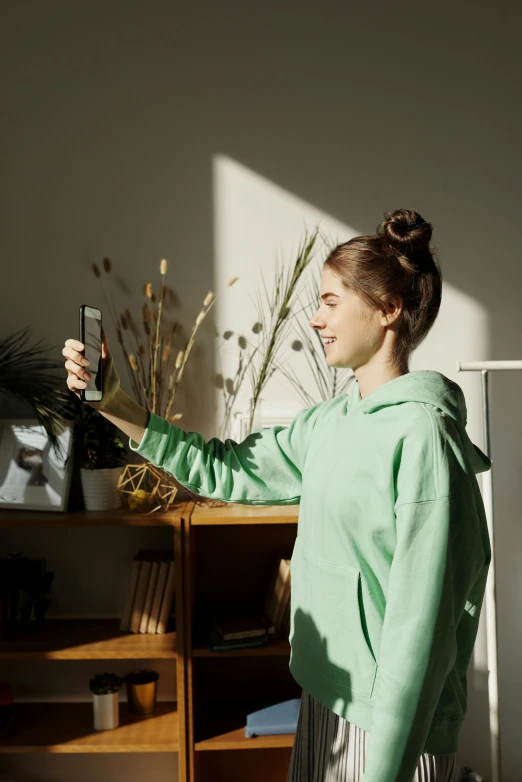 a woman standing in front of a refrigerator holding a bottle, a picture, trending on pexels, happening, wearing a green sweater, phone camera, nice spring afternoon lighting, avatar image