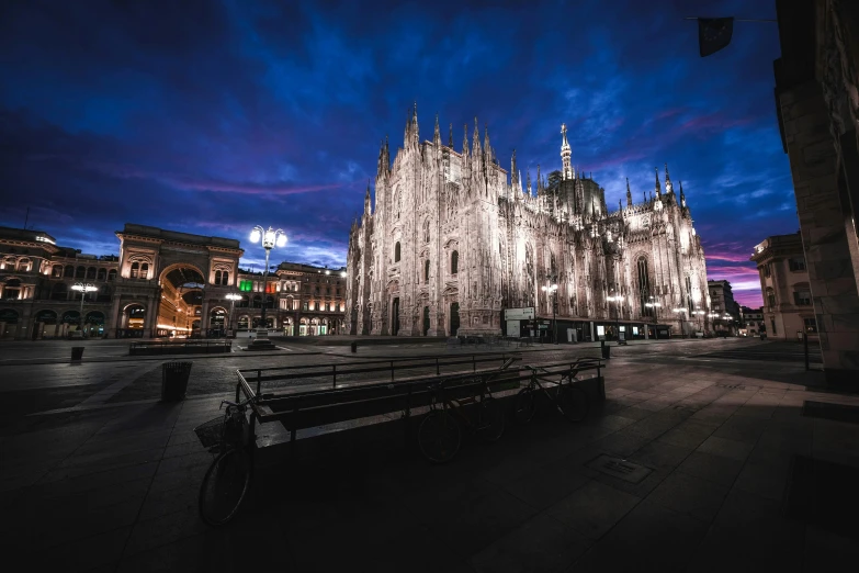 a bench sitting in front of a large cathedral, by Carlo Martini, pexels contest winner, night time footage, milan schere, gopro photo, tie-dye