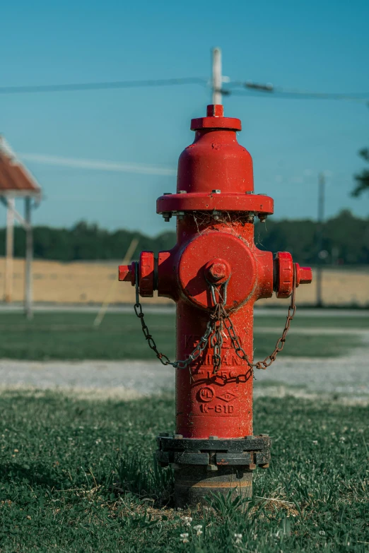 a red fire hydrant sitting on top of a lush green field, by Chris Rahn, pexels contest winner, square, on a football field, crying engine, water fountain