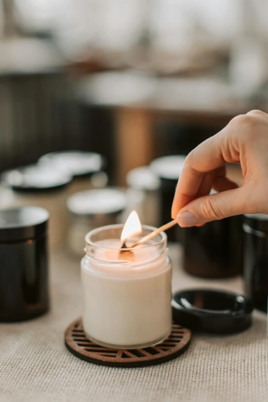 a person lighting a candle on a table, trending on pexels, manuka, crafts and souvenirs, profile image, vanilla