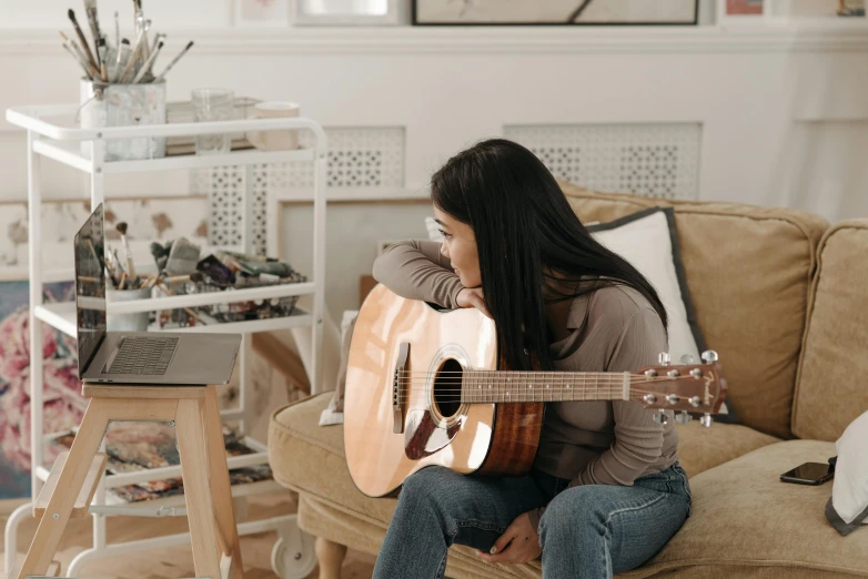 a woman sitting on a couch playing a guitar, pexels contest winner, profile image, pokimane, joanna gaines, mai anh tran
