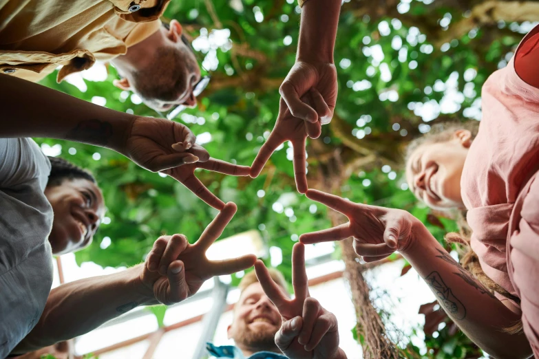 a group of people making a star with their hands, by Jessie Algie, pexels contest winner, symbolism, permaculture, schools, avatar image, full frame image