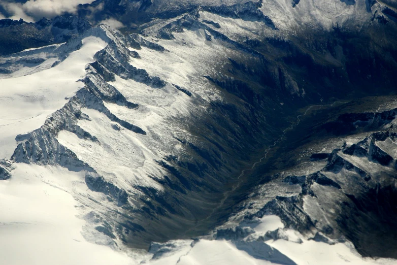 an aerial view of a snow covered mountain range, by Peter Churcher, pexels contest winner, hurufiyya, seen from space, huge chasm, photographed for reuters, mount doom