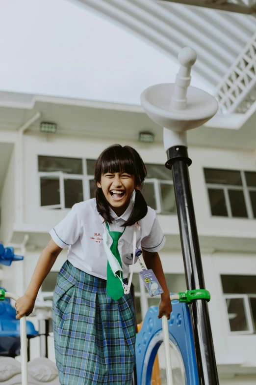 a little girl standing on top of a blue scooter, inspired by Ni Yuanlu, pexels contest winner, happening, wearing school uniform, laughter and screaming face, indonesia, school courtyard