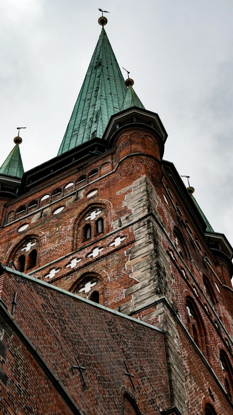 a clock that is on the side of a building, an album cover, by Harry Haenigsen, unsplash, romanesque, nordic crown, lead - covered spire, brick building, high-body detail