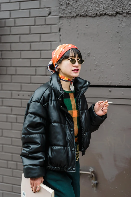 a woman in a black jacket smoking a cigarette, by Nina Hamnett, trending on pexels, colorful bandana, orange reflective puffy coat, jackie tsai style, straight bangs