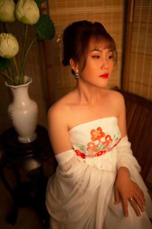a woman in a white dress sitting next to a vase of flowers, an album cover, inspired by Xie Sun, happening, in style of lam manh, “ sensual, slide show, closeup - view