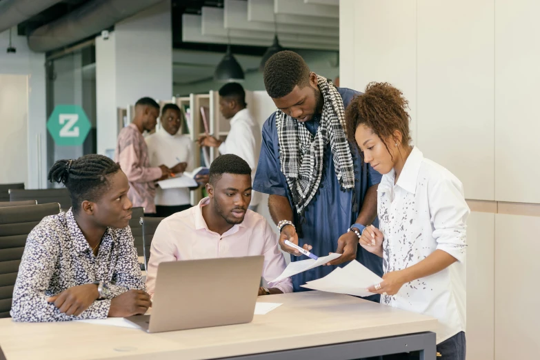 a group of people sitting around a table with a laptop, on a desk, afro tech, carefully designed, thumbnail