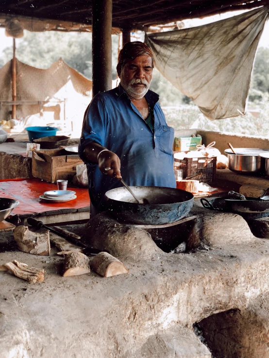 a man standing in front of a table filled with pots and pans, uttarakhand, cooking pizza, profile image