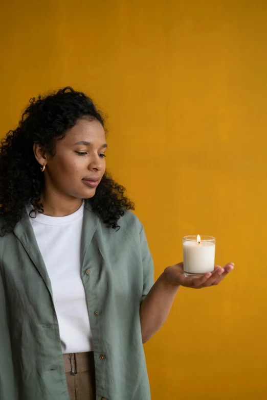 a woman holding a candle in her hand, curated collections, contemplating, full product shot, centred