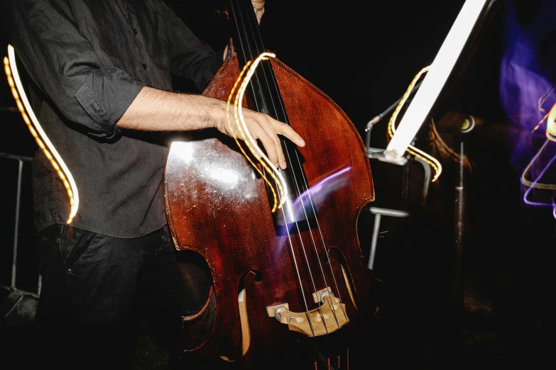 a man playing a double bass in a dark room, unsplash, big wooden club, close - up photograph, 15081959 21121991 01012000 4k, lachlan bailey