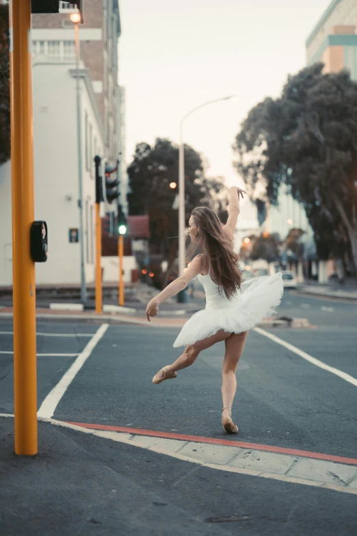 a woman in a white dress is dancing on the street, by Elizabeth Polunin, unsplash contest winner, arabesque, australia, square, snapchat photo, silver，ivory