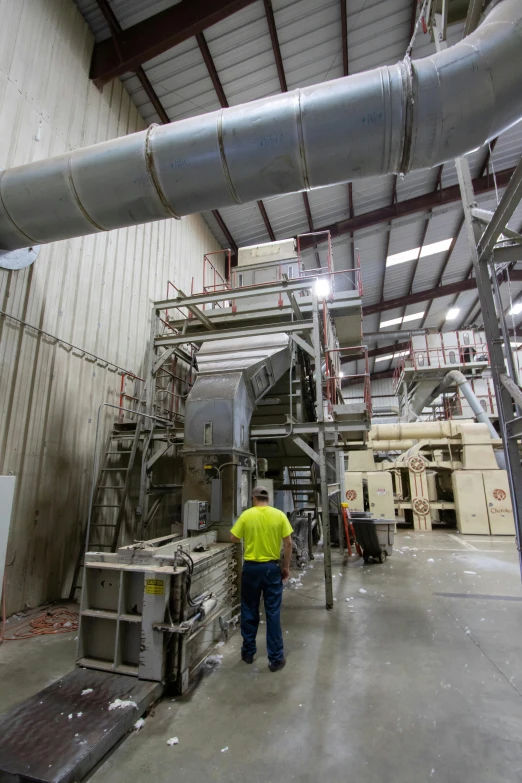 a man standing in front of a machine in a factory, biroremediation plant, large screens, idaho, thumbnail