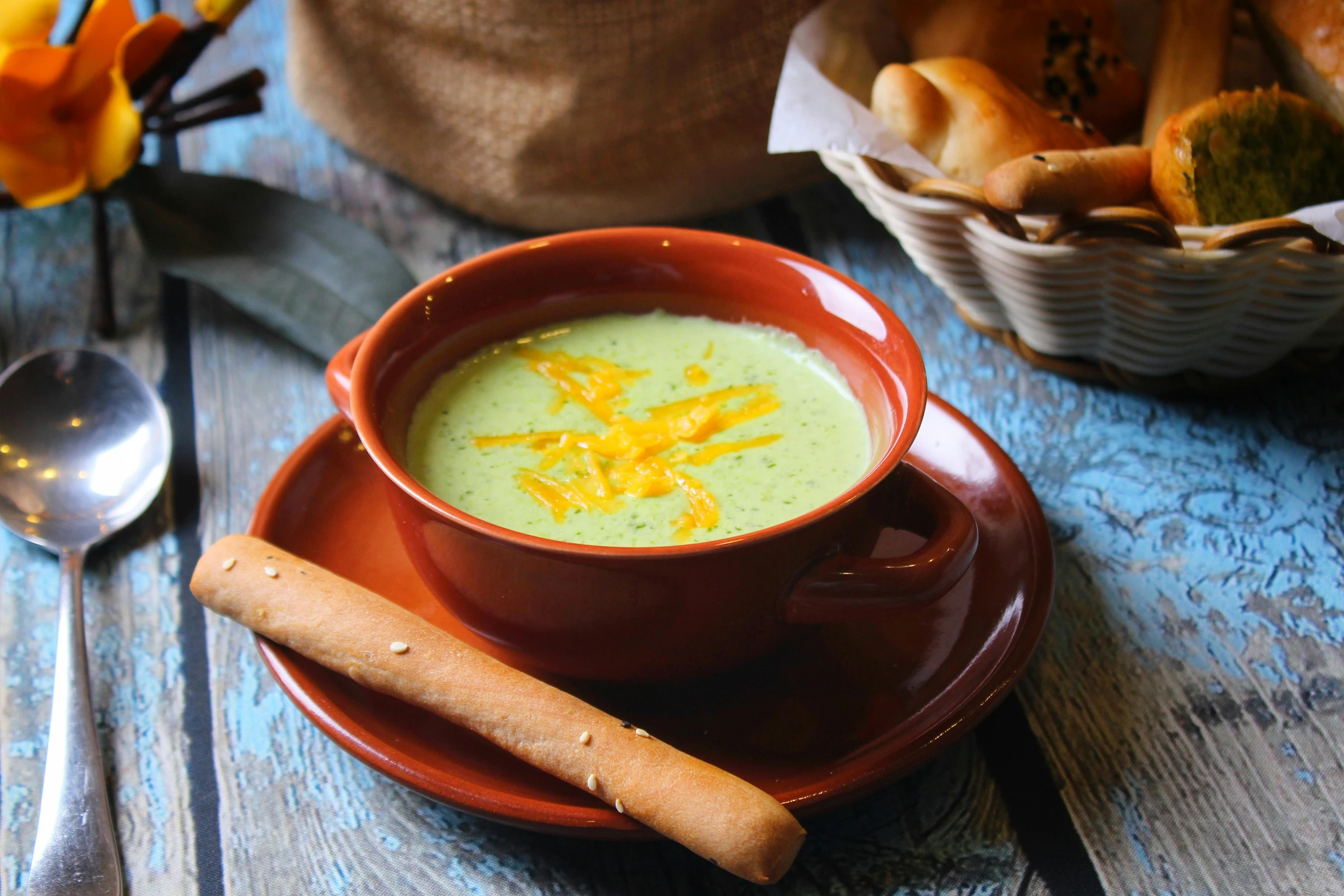 a bowl of soup sitting on top of a wooden table, inspired by Géza Dósa, pexels contest winner, hurufiyya, pastel green, cheesy, square, cane