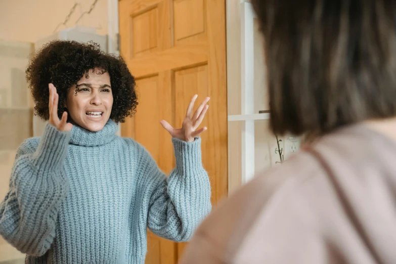 a woman standing in front of a mirror talking on a cell phone, reaching out to each other, dark short curly hair smiling, nearest neighbor, promo image