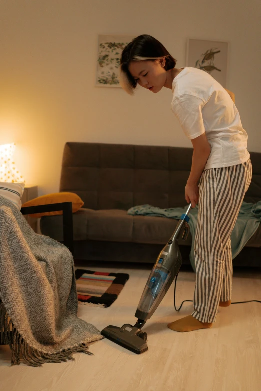 a woman using a vacuum cleaner in a living room, by Julia Pishtar, featured on reddit, asian women, floor lamps, studio photo, made of high tech materials