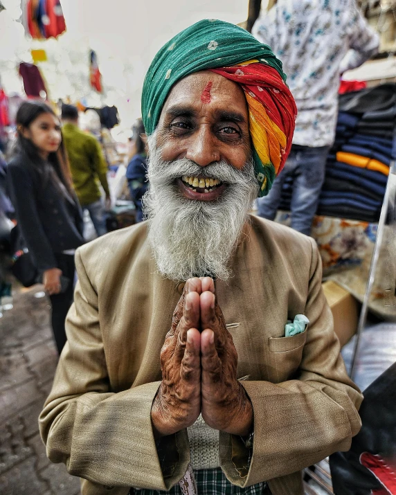 a man with a long beard wearing a turban, pexels contest winner, blessing hands, lgbtq, smiling for the camera, temple fair