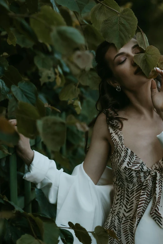 a woman in a white dress holding a leaf, inspired by Elsa Bleda, pexels contest winner, renaissance, video still, jungle gown, smelling good, seducing