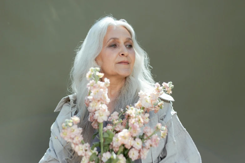 a woman with white hair holding a bunch of flowers, inspired by Anna Füssli, hurufiyya, press shot, light gray long hair, dayanita singh, avatar image