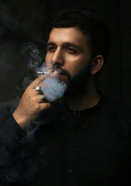 a man smoking a cigarette in a dark room, an album cover, inspired by Yousuf Karsh, pexels contest winner, hurufiyya, he is a long boi ”, hindu, young male, middle eastern