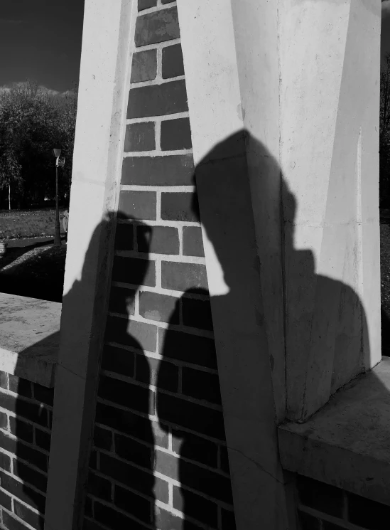 a black and white photo of a person on a skateboard, a black and white photo, inspired by Vivian Maier, faces covered in shadows, untethered stelae, hiding behind a brick wall, selfie photo