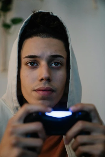 a close up of a person playing a video game, inspired by Jean Malouel, pexels contest winner, renaissance, full face shot, hood, light skin, bad bunny