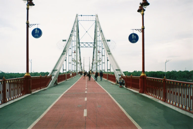 a group of people walking across a bridge, by Jacob Toorenvliet, unsplash, art nouveau, soviet town, 000 — википедия, red river, 1990s photograph