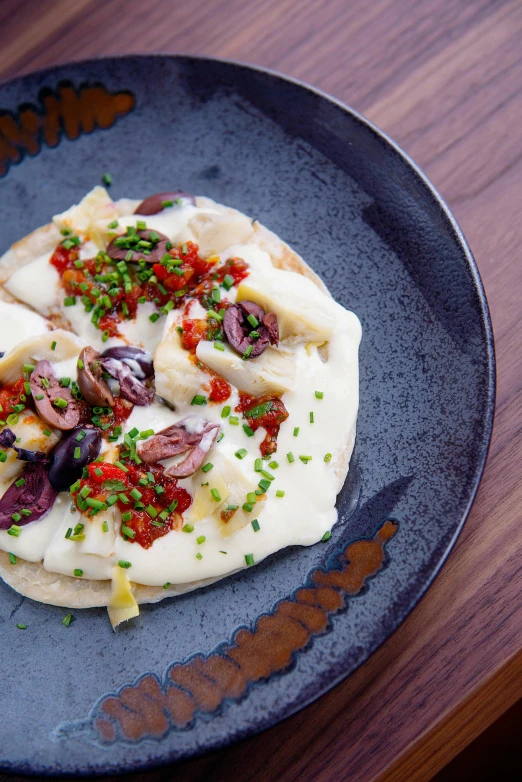 a close up of a plate of food on a table, hurufiyya, jaime jasso, restaurant, pizza cosmos, cream