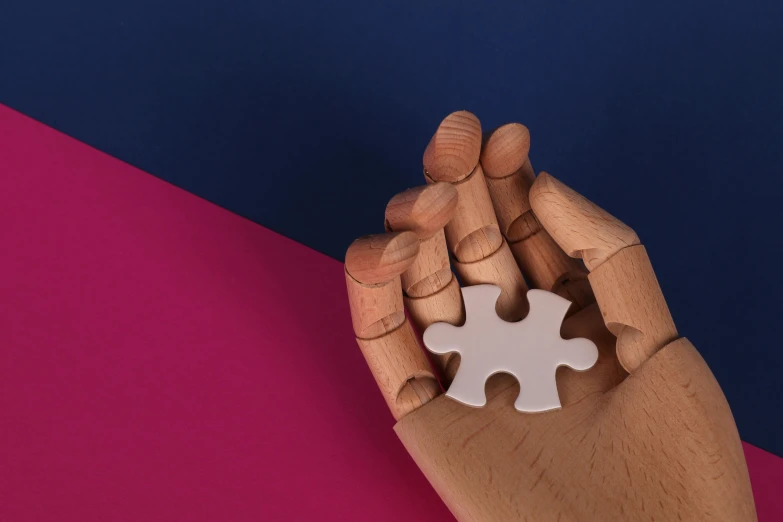 a person holding a puzzle piece in their hand, inspired by Tom Wesselmann, trending on pexels, aestheticism, sculpture made of wood, clemens ascher, pink and blue colour, with a white complexion