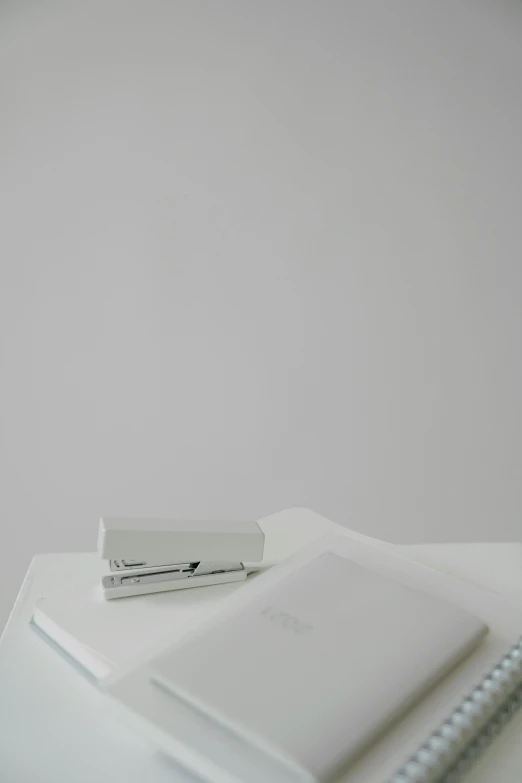 a white laptop computer sitting on top of a white table, various items, white gallery, miscellaneous objects, item