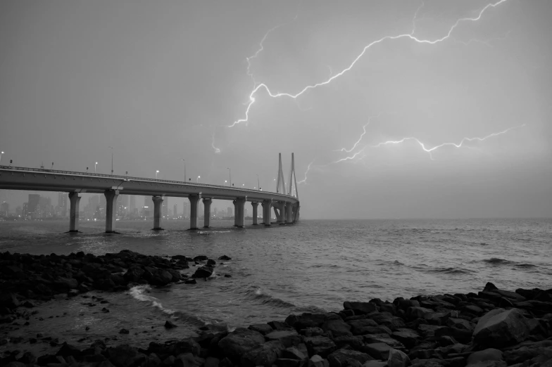 a black and white photo of lightning over a bridge, by Jitish Kallat, pexels contest winner, mumbai in the future, caspar friedrich, trident, bolts