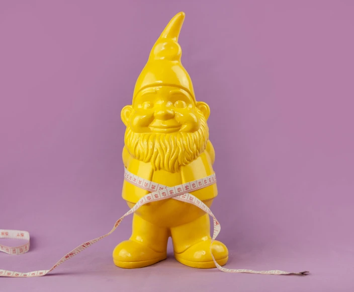 a yellow statue of a gnome holding a measuring tape, inspired by Sarah Lucas, gloss finish, vivid studio light, offwhite, medium-shot