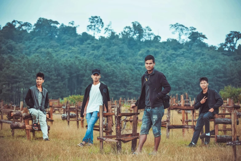 a group of men standing next to each other in a field, an album cover, pexels contest winner, sumatraism, nivanh chanthara, in a metal forest, casual pose, shot on sony a 7